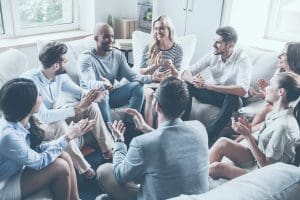 People sat around in a group talking adnsmiling